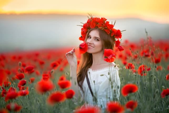 a young woman posing with flowers in the field