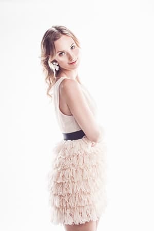 a woman wearing white posing with a flower in her hair
