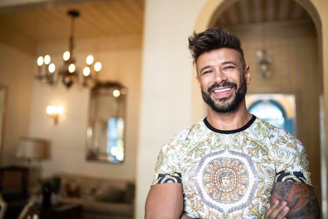 an attractive masculine man is laughing and smiling