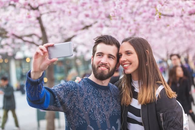 a couple taking a selfie outside together