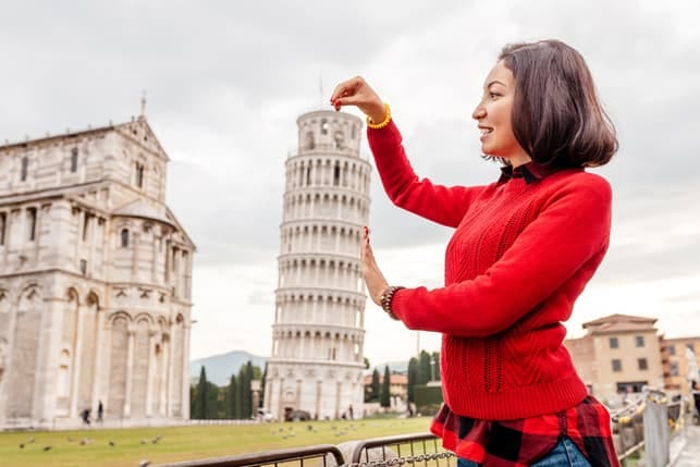 a portrait of a woman posing next to a Pisa tower