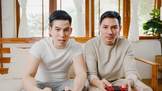 an asian gay couple playing video games together