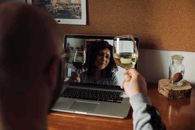 a couple drinking wine together via a video call