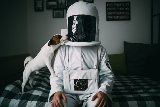 an astronaut with his dog at home