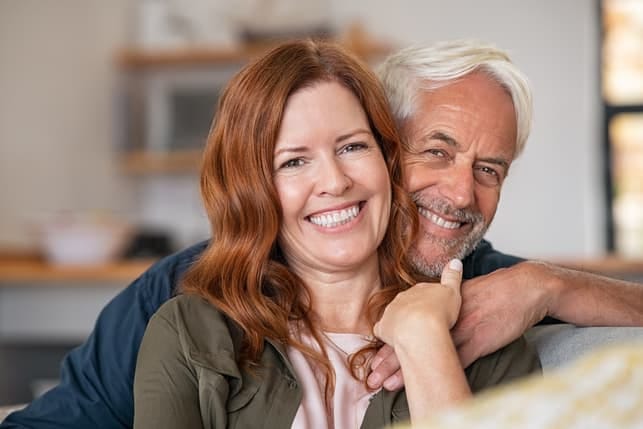 a mature couple is posing at home together