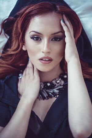 a portrait of a redhead woman in black