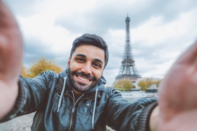 a man is taking a selfie with an eiffel tower