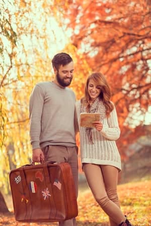 a couple is walking outdoors in autumn