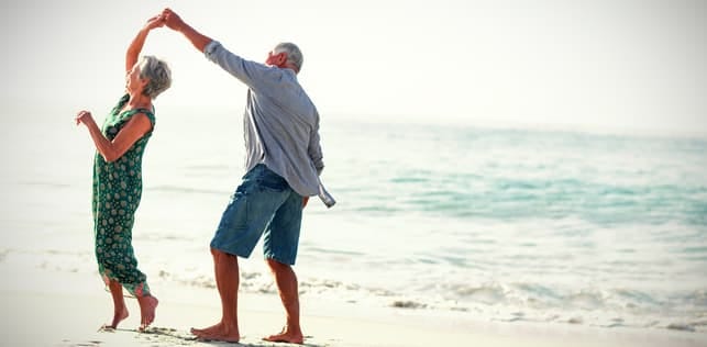 a senior couple dancing together on the seaside