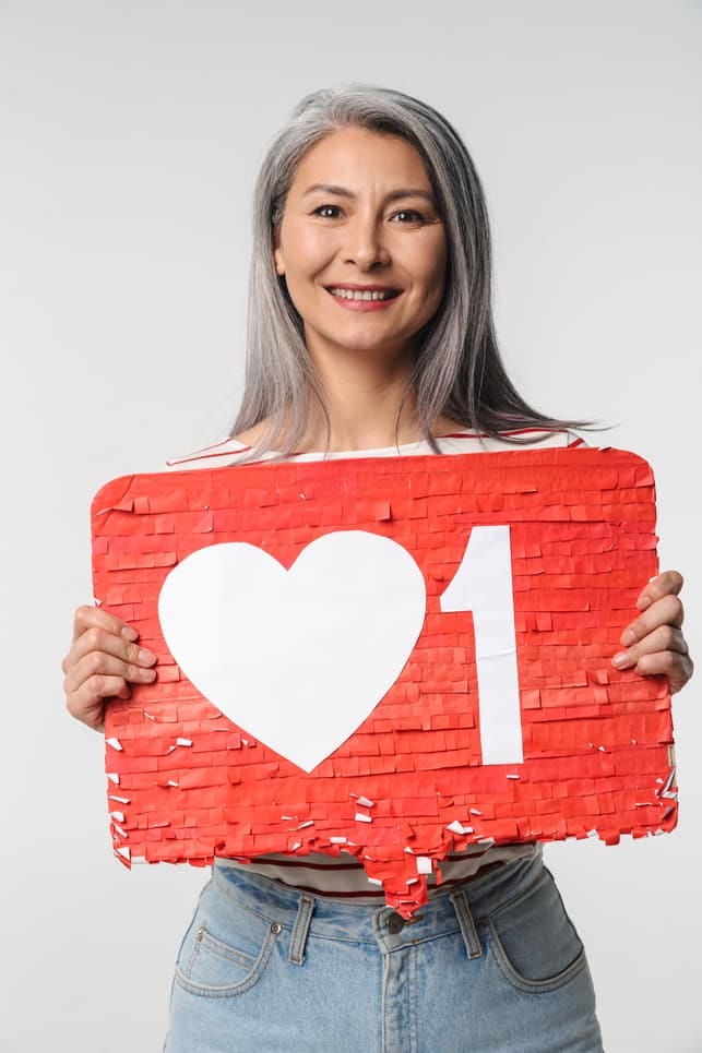 a portrait of a mature woman holding a like sign