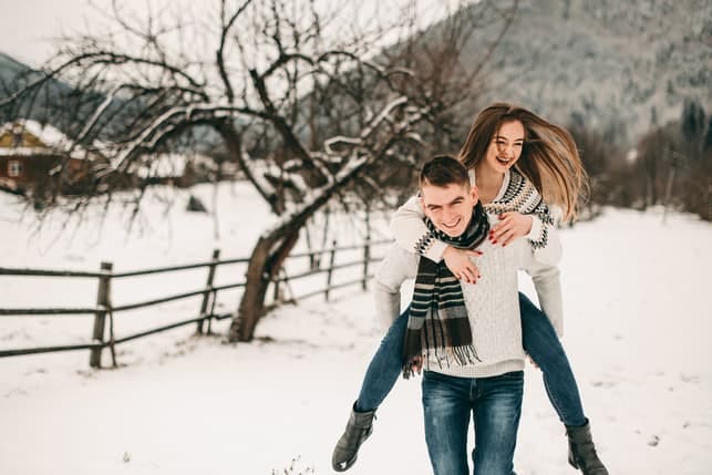 a couple is having fun outside in winter
