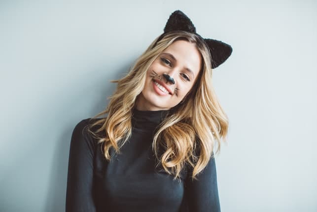 an attractive blonde woman with cat ears is smiling