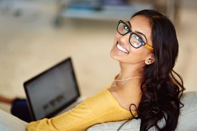 a young Indian girl in glasses using her computer