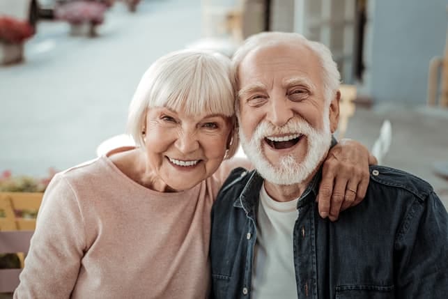 a couple of seniors is posing together while laughing