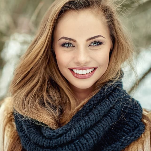 a beautiful blonde woman posing outside in winter