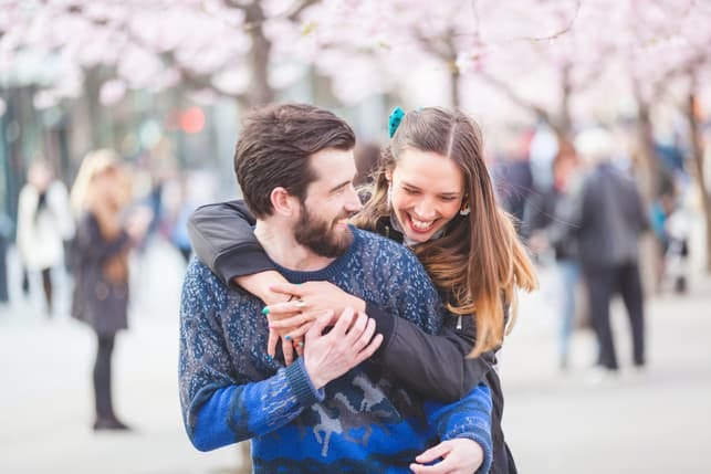 a couple hugging and having fun while walking outdoors