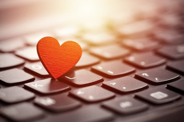 a laptop’s keyboard with a little heart on it