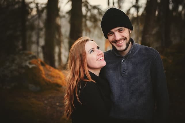 a happy couple posing in the forest together