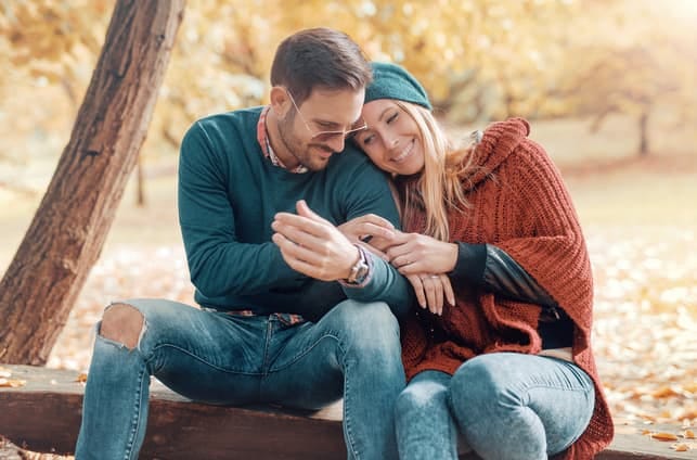 a young couple cuddling while having a date in a park