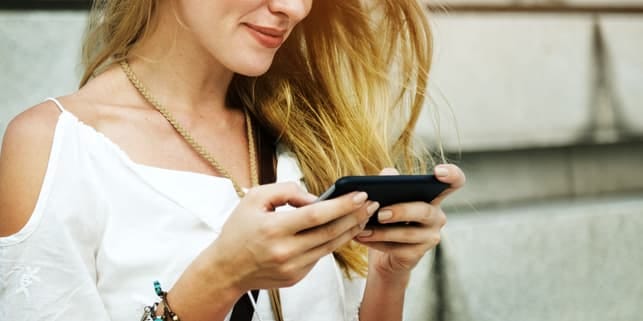 a girl using her phone and smiling