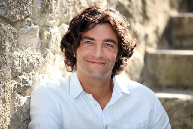 a handsome smiling French man posing