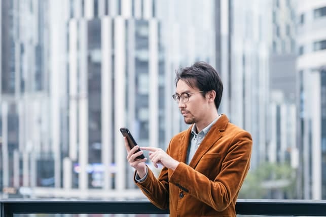 an Asian man using his smartphone