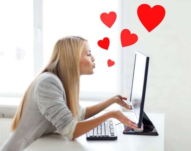 a woman sending hearts to the monitor of her laptop