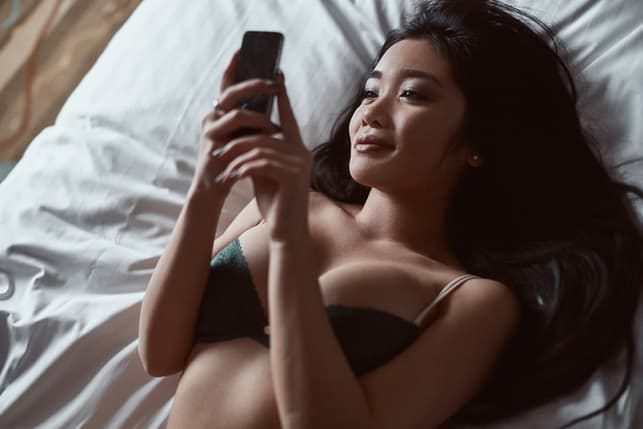 an attractive Asian woman using her smartphone